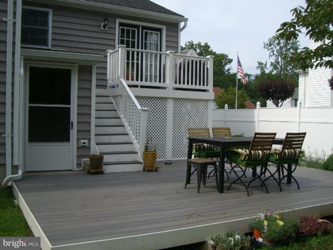 61 Yew Road Baltimore, MD 21221 - Photo 22 of 30 a view of a patio with table and chairs and potted plants with wooden floor and fence