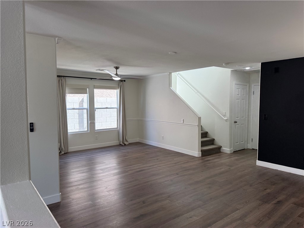 1141 Cathedral Ridge Street Henderson, NV 89052 - Photo 12 of 77 This airy living space features rich wood flooring and a staircase, offering versatile design possibilities.