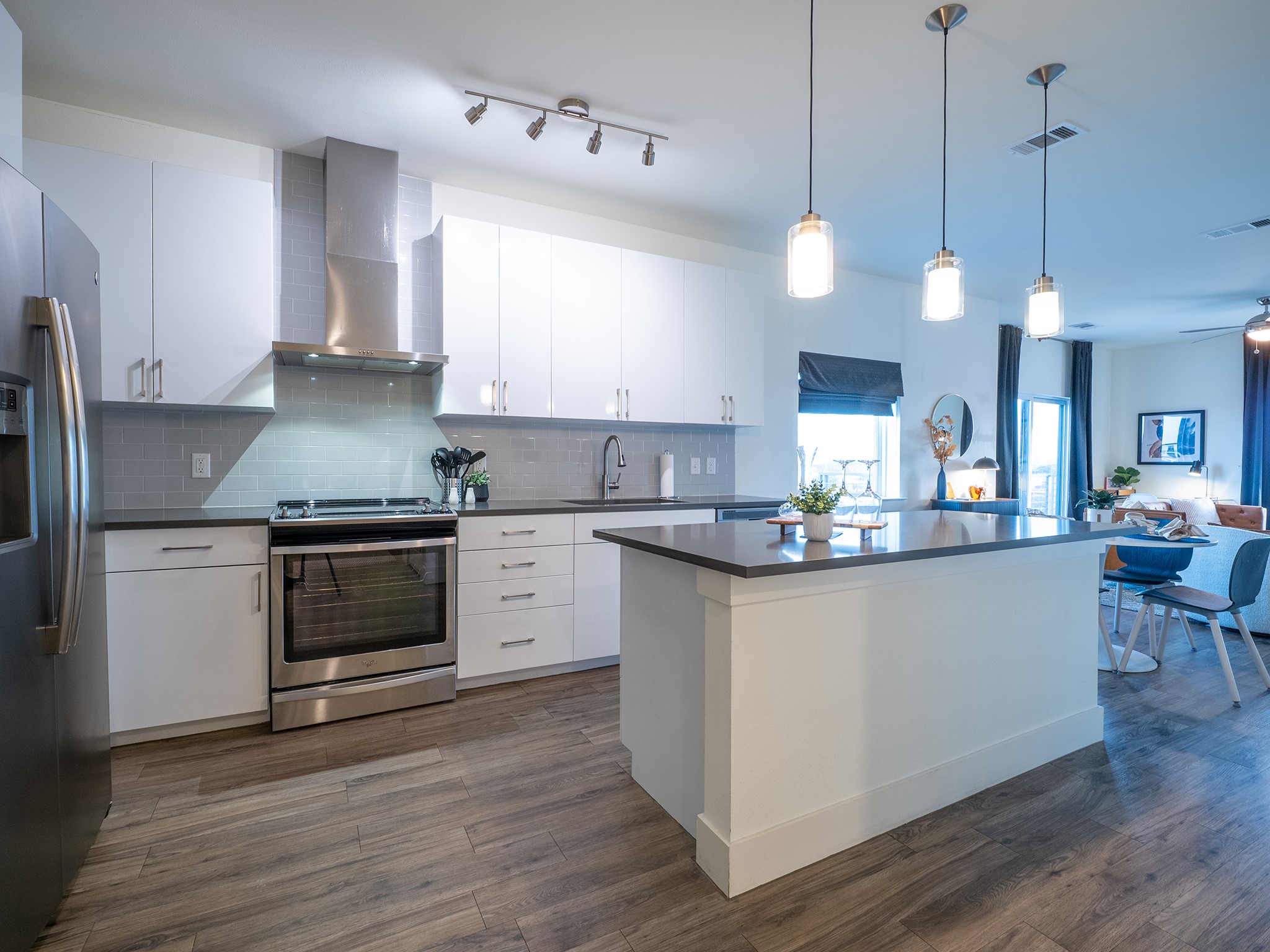 6444 Burnet Road, Unit 509 Austin, TX 78757 - Photo 32 of 32 Kitchen featuring stainless steel appliances, white cabinetry, decorative light fixtures, a kitchen island, and open floor plan
