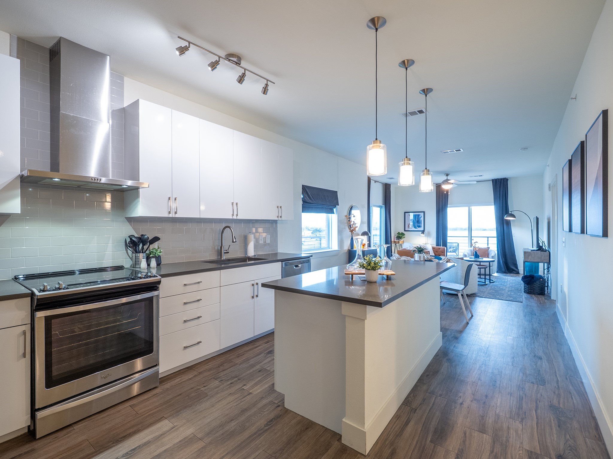 6444 Burnet Road, Unit 509 Austin, TX 78757 - Photo 2 of 32 Kitchen with stainless steel appliances, backsplash, decorative light fixtures, white cabinetry, and a center island