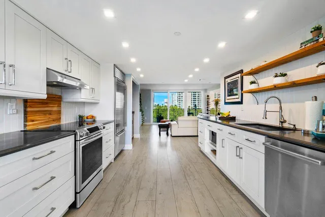 a large kitchen with stainless steel appliances lots of counter space and wooden floor