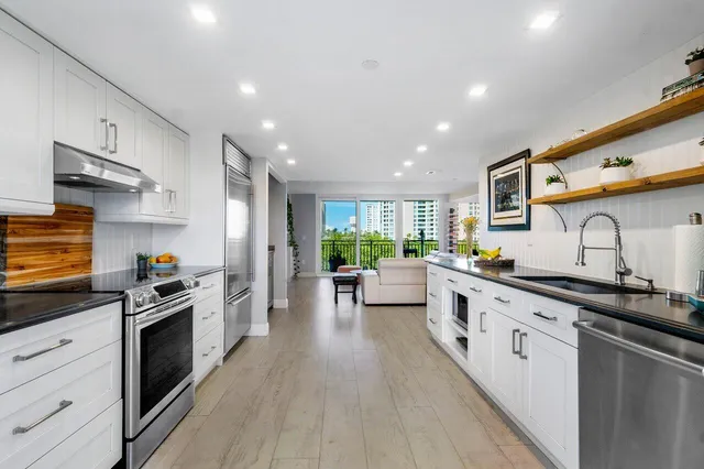 a kitchen with stainless steel appliances a sink stove and cabinets