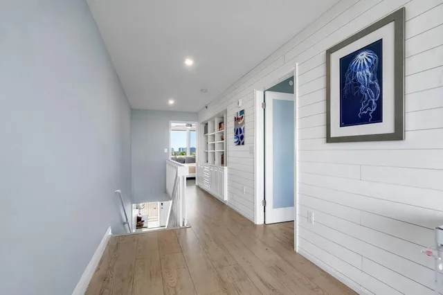 a view of a hallway with wooden floor and closet