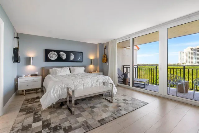 a bedroom with a large bed and a chandelier