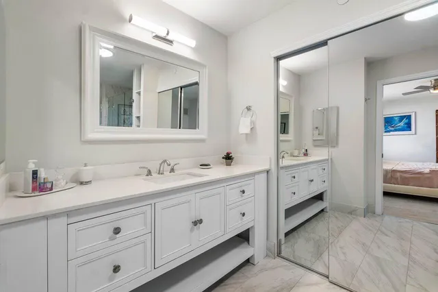 a spacious en suite bathroom with double sink and mirrors