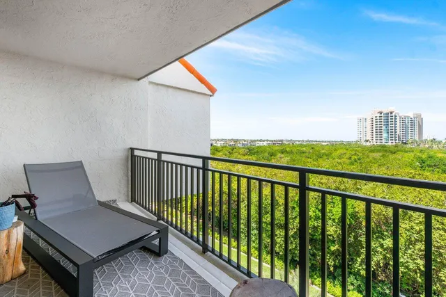 a view of a balcony with chair and wooden floor