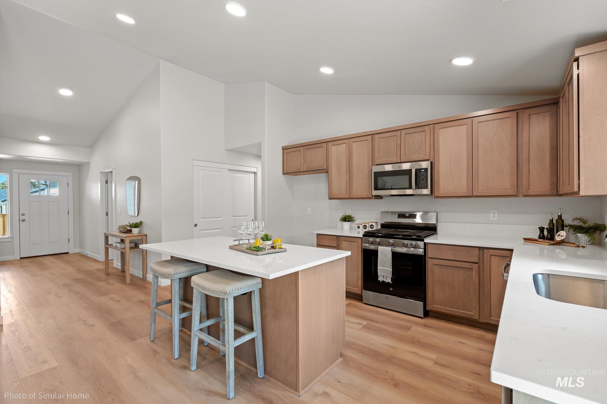 2041 Sumac Avenue Middleton, ID 83644 - Photo 2 of 8 Kitchen with stainless steel appliances, a kitchen island, light wood-style flooring, light stone countertops, and recessed lighting