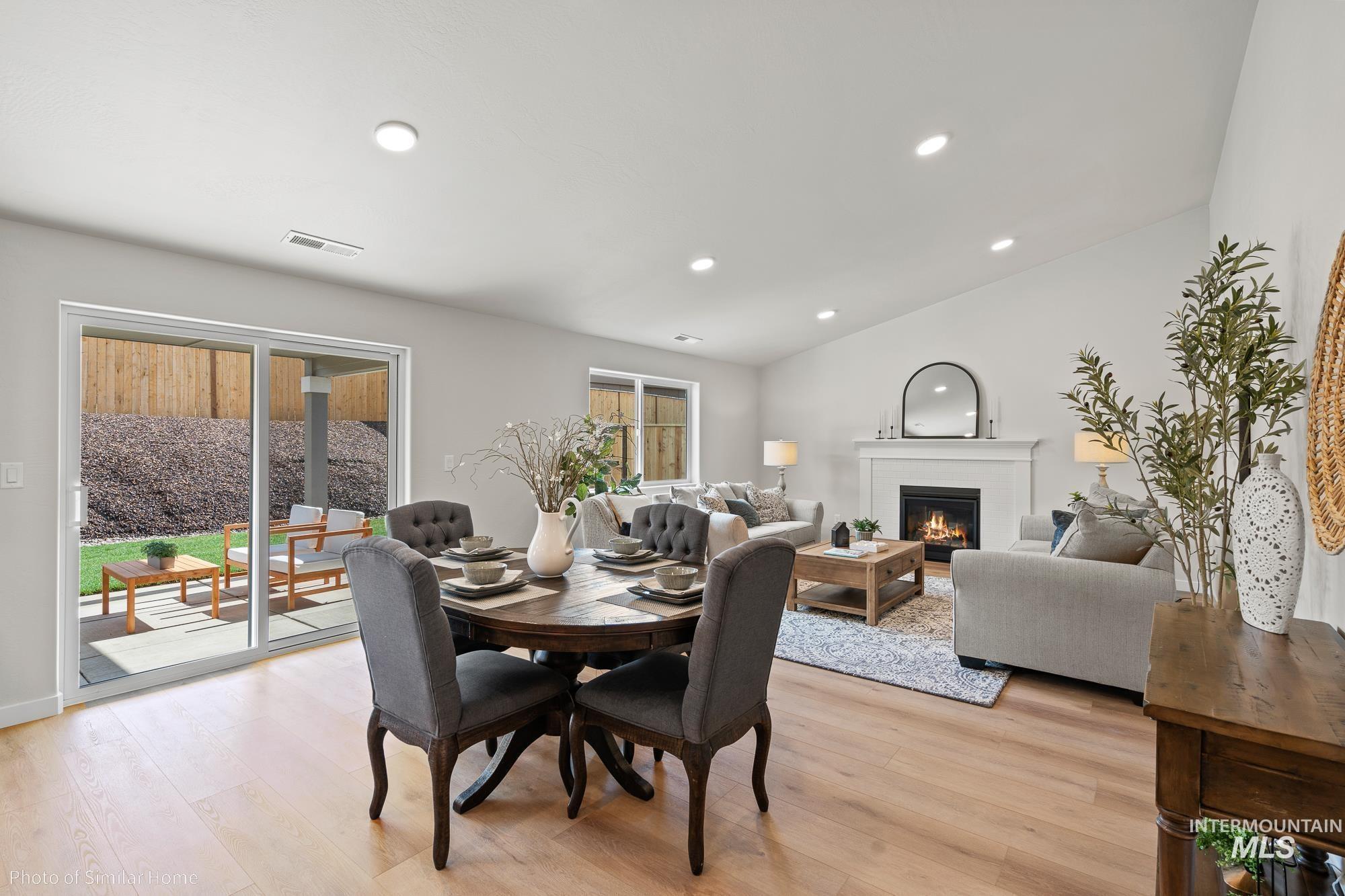 2041 Sumac Avenue Middleton, ID 83644 - Photo 3 of 8 Dining room featuring a glass covered fireplace, light wood-style flooring, vaulted ceiling, and recessed lighting