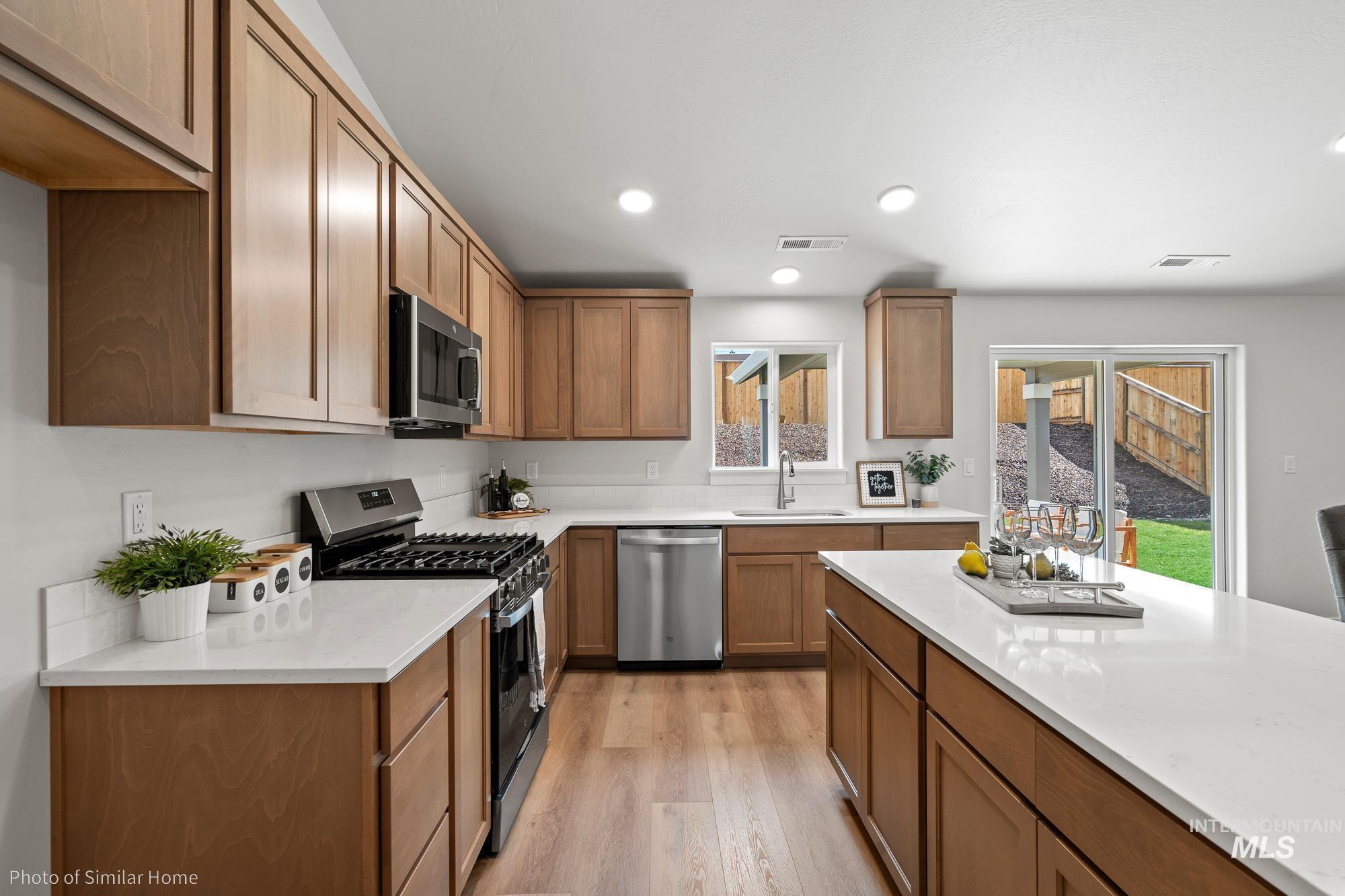 2041 Sumac Avenue Middleton, ID 83644 - Photo 4 of 8 Kitchen featuring stainless steel appliances, light wood-type flooring, brown cabinetry, recessed lighting, and light stone counters