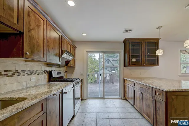 a kitchen with stainless steel appliances granite countertop a stove a sink and a microwave