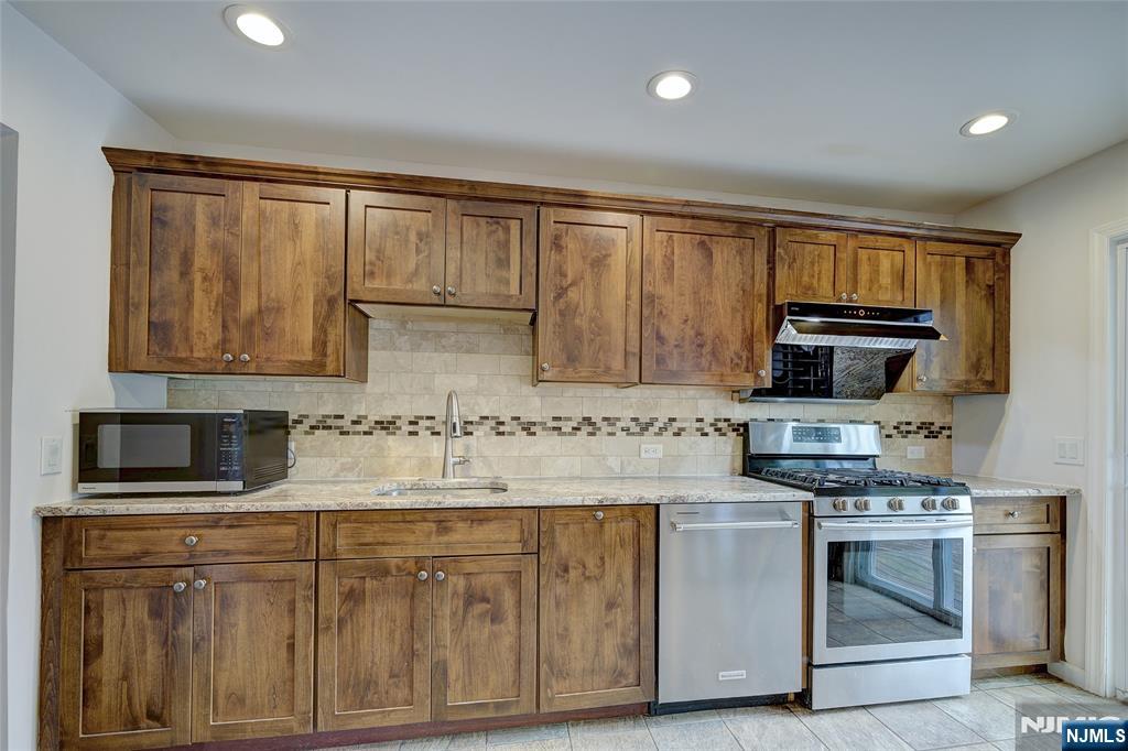 819 Ridgewood Road Millburn, NJ 07041 - Photo 13 of 39 a kitchen with stainless steel appliances granite countertop a stove a sink and a microwave
