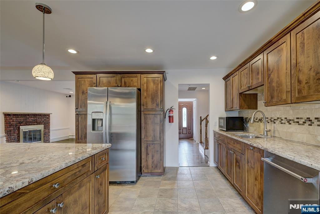 819 Ridgewood Road Millburn, NJ 07041 - Photo 14 of 39 a kitchen with stainless steel appliances granite countertop a refrigerator a oven a sink with a countertop and wooden cabinets