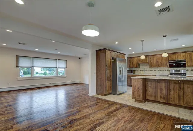 a view of kitchen with stainless steel appliances refrigerator stove microwave and cabinets
