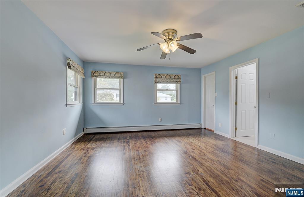 819 Ridgewood Road Millburn, NJ 07041 - Photo 17 of 39 a view of an empty room with wooden floor and a window
