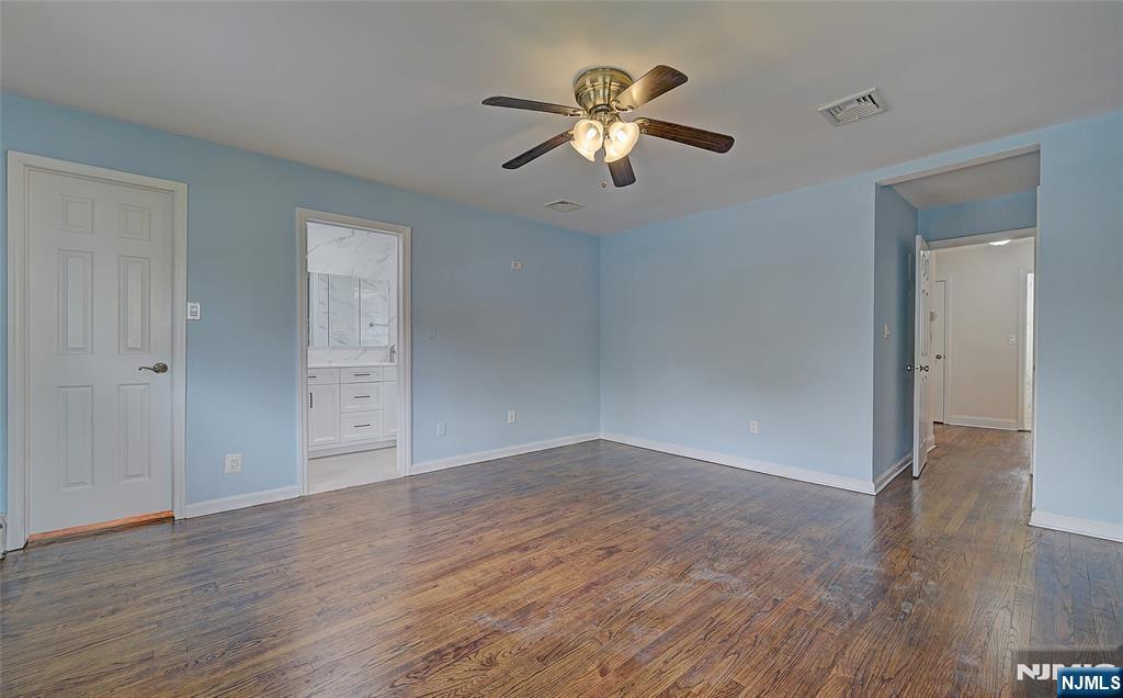 819 Ridgewood Road Millburn, NJ 07041 - Photo 18 of 39 an empty room with wooden floor chandelier fan and windows
