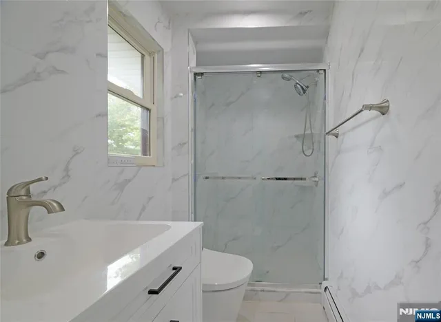 a bathroom with a sink a toilet and shower