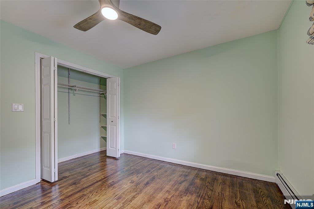 819 Ridgewood Road Millburn, NJ 07041 - Photo 25 of 39 an empty room with wooden floor closet and fan