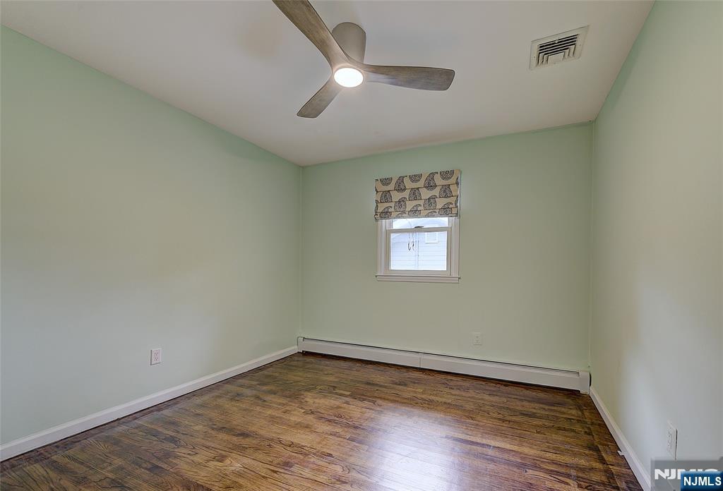 819 Ridgewood Road Millburn, NJ 07041 - Photo 26 of 39 an empty room with wooden floor ceiling fan and window
