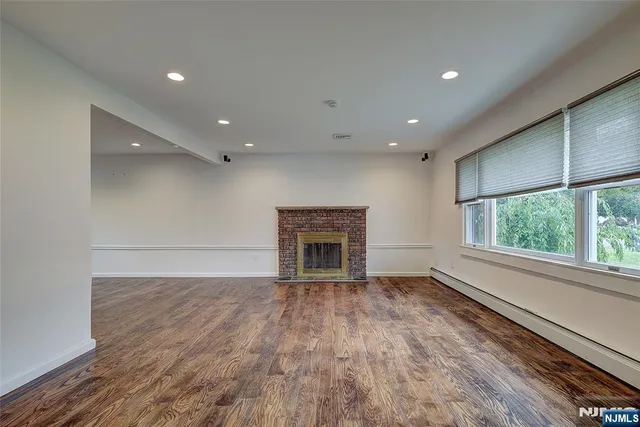 a view of an empty room with a fireplace and a window