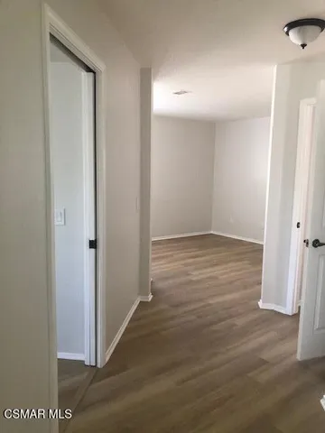 an empty room with wooden floor and entrance