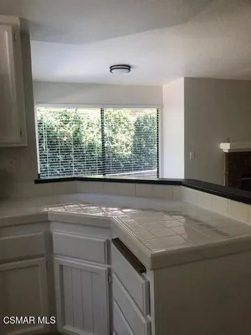 a view of a kitchen cabinets a sink and dishwasher a stove top oven with wooden floor
