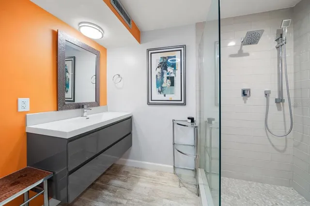 a bathroom with a granite countertop sink mirror and shower