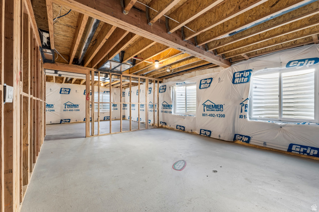 58 South Crimson Way, Unit 306 Mapleton, UT 84664 - Photo 23 of 24 Unfinished lower level with wood framing, exposed ceiling joists, concrete flooring, and multiple window openings
