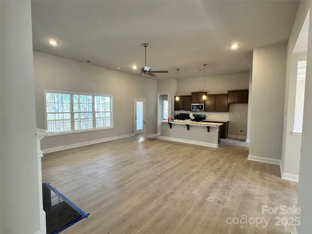 an empty room with windows and fireplace