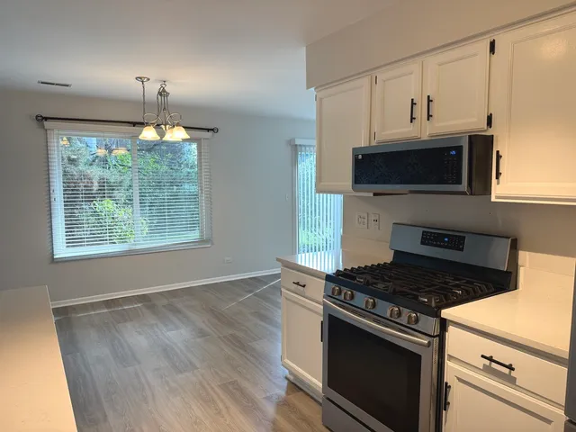 a kitchen with cabinets appliances and a window