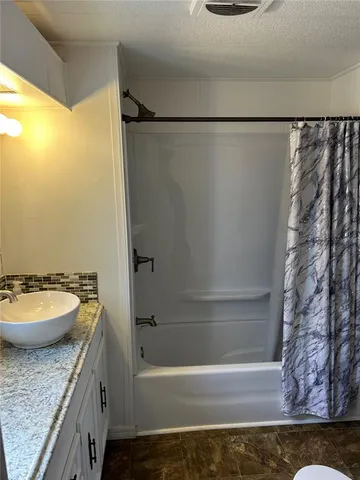 a bathroom with a granite countertop sink toilet and mirror