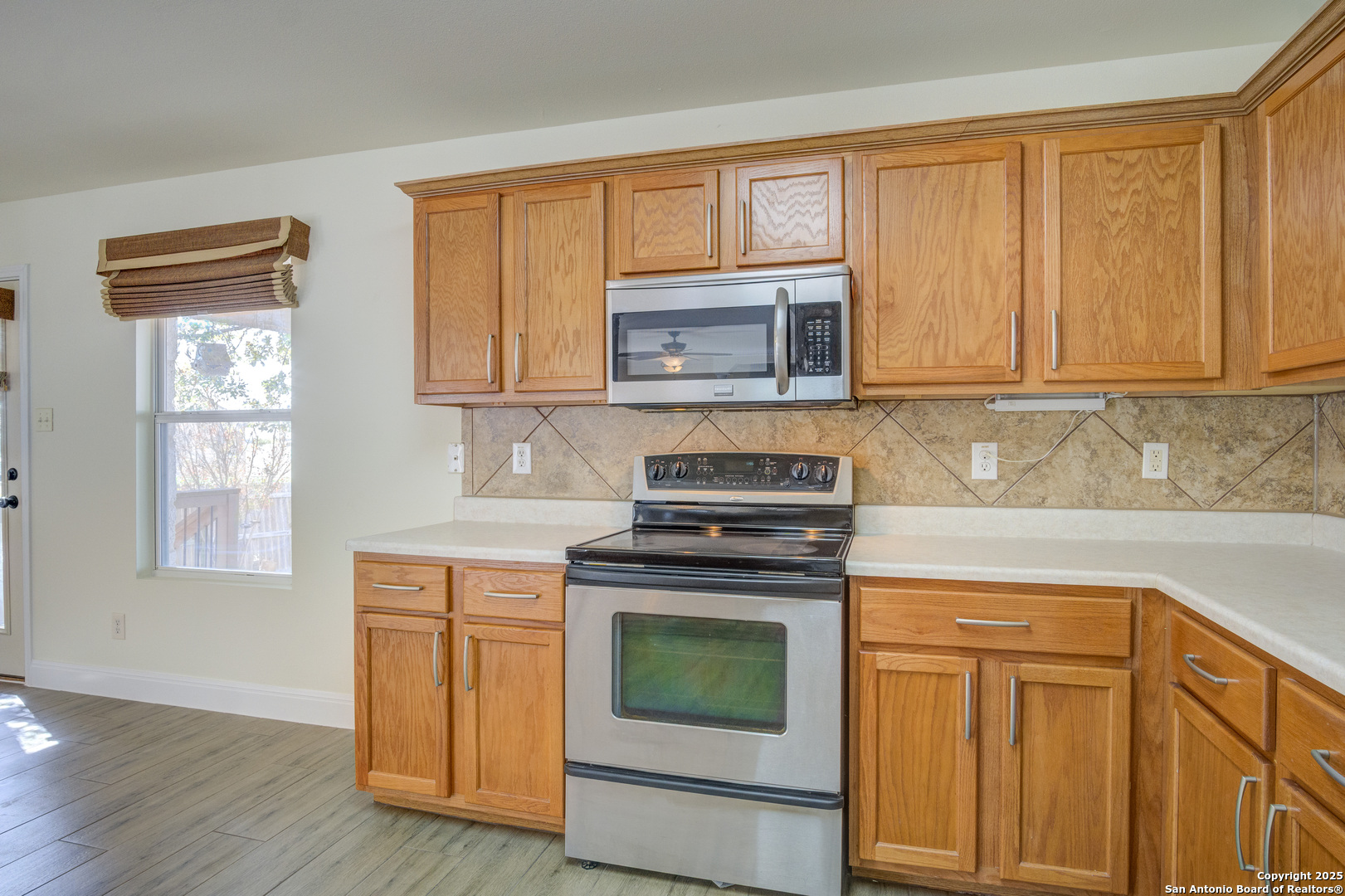 145 Stream Crossing Cibolo, TX 78108 - Photo 24 of 40 a kitchen with granite countertop wooden cabinets and a stove top oven