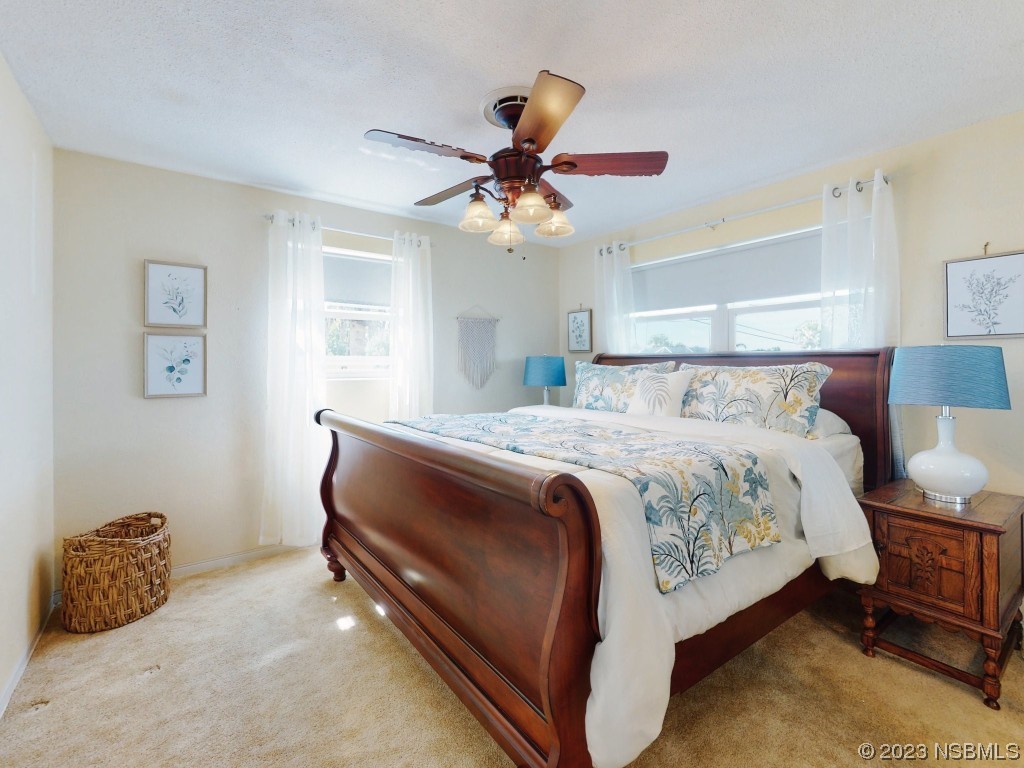 18 Silk Oaks Drive Ormond Beach, FL 32176 - Photo 22 of 46 a bedroom with a bed and a chandelier