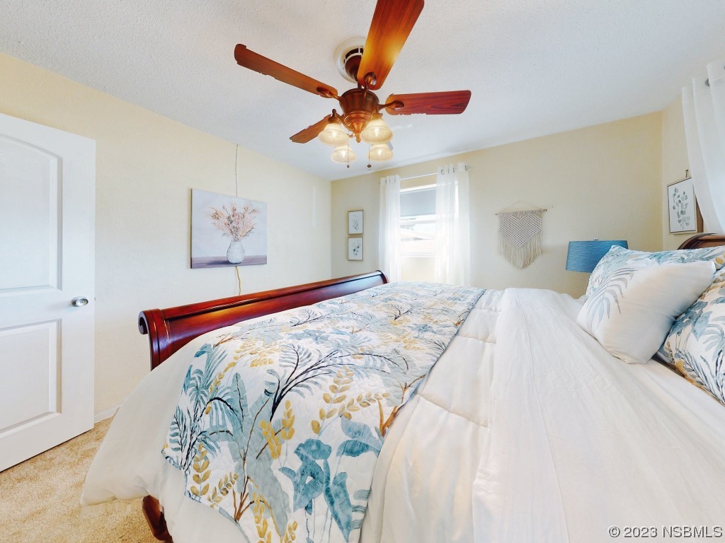 18 Silk Oaks Drive Ormond Beach, FL 32176 - Photo 23 of 46 a bedroom with a bed and a chandelier