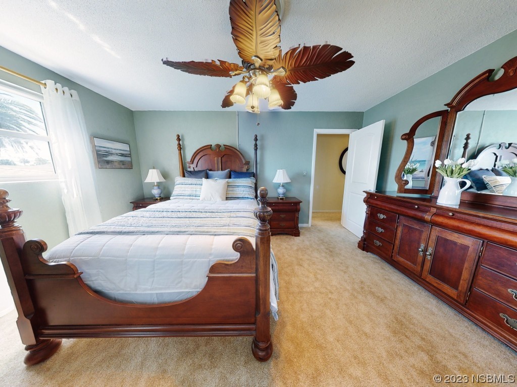 18 Silk Oaks Drive Ormond Beach, FL 32176 - Photo 27 of 46 a bedroom with a bed and dresser with mirror