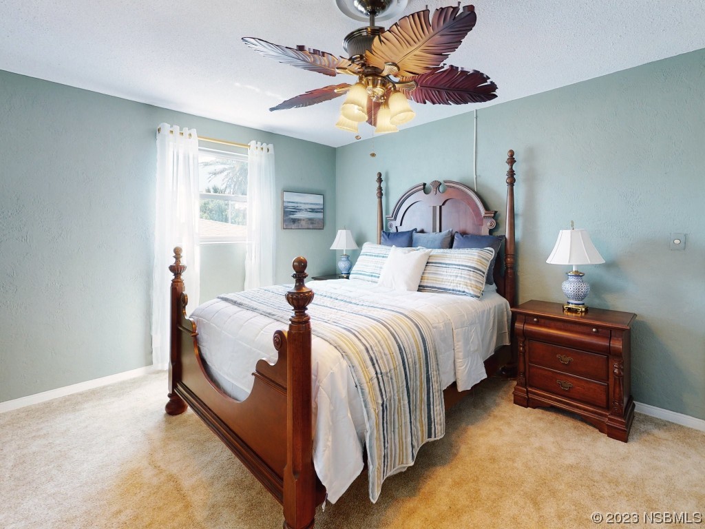 18 Silk Oaks Drive Ormond Beach, FL 32176 - Photo 29 of 46 a bedroom with a bed and a chandelier