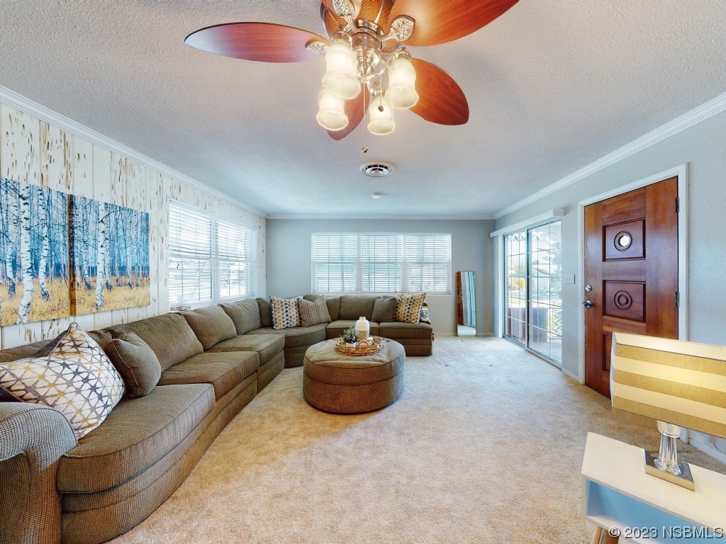18 Silk Oaks Drive Ormond Beach, FL 32176 - Photo 9 of 46 a living room with furniture a chandelier and a large window