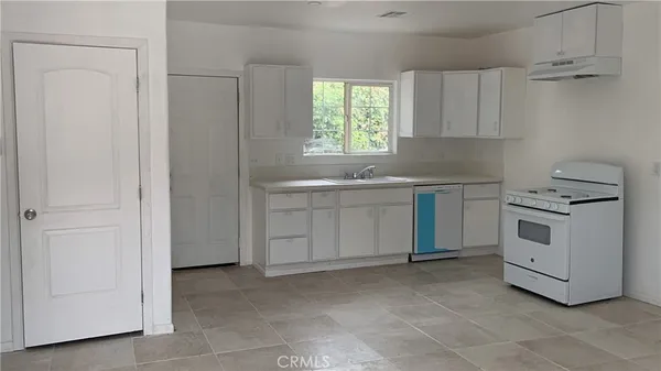 a kitchen with white cabinets and white appliances