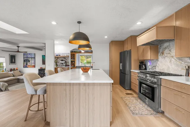 a kitchen with stainless steel appliances granite countertop a refrigerator and a sink