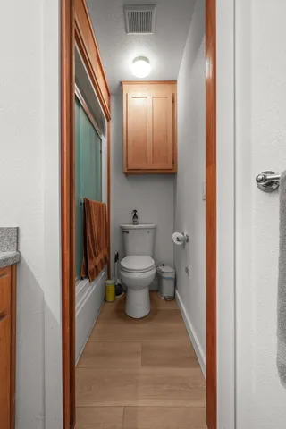 a side view of a house with a small yard and potted plants