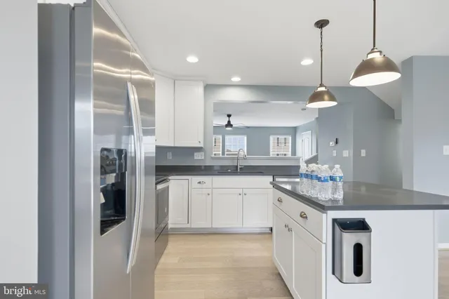 a kitchen with stainless steel appliances granite countertop a sink a stove and a refrigerator
