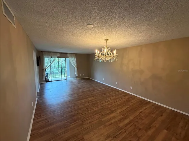 a view of a room with wooden floor and chandelier