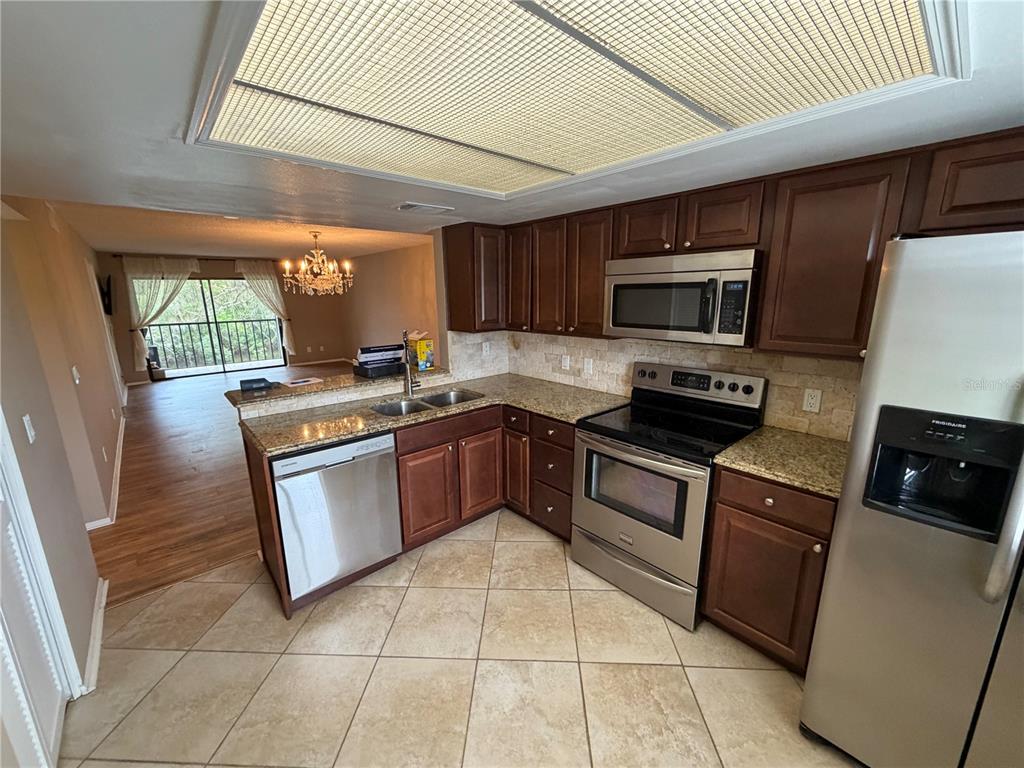 274 Cypress Lane Oldsmar, FL 34677 - Photo 3 of 19 a kitchen with stainless steel appliances granite countertop a stove microwave and sink