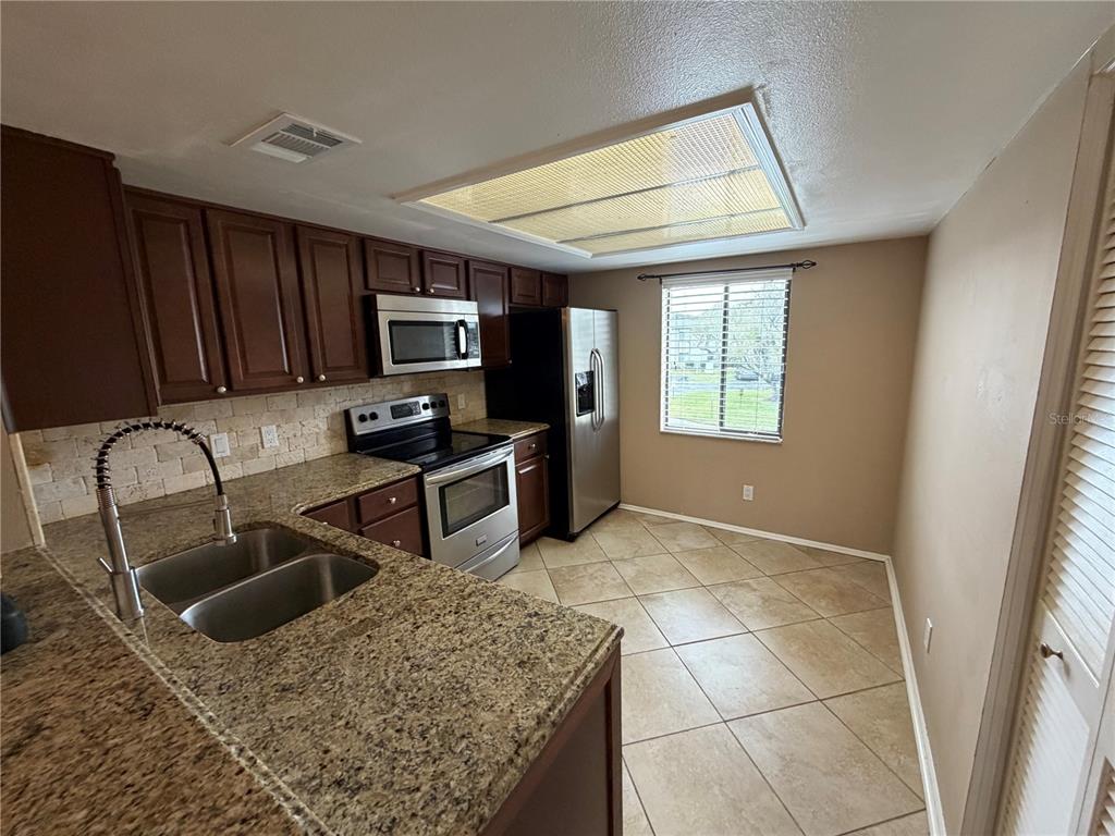 274 Cypress Lane Oldsmar, FL 34677 - Photo 4 of 19 a kitchen with stainless steel appliances granite countertop a sink stove and refrigerator