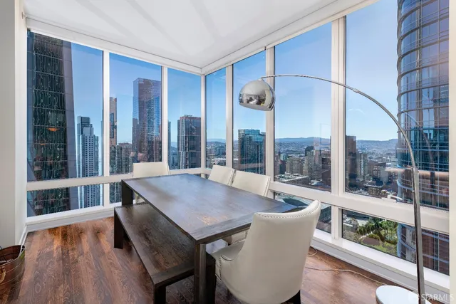 a view of a living room with a table and chairs