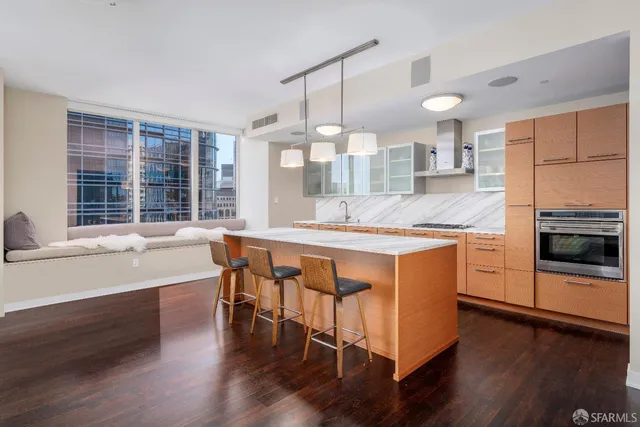 a kitchen with stainless steel appliances granite countertop wooden floors and white cabinets