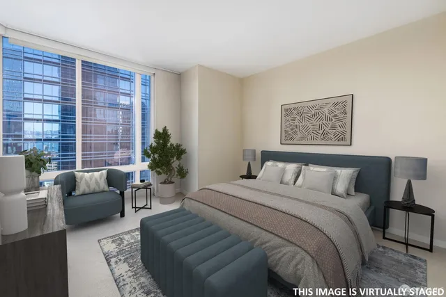 a bedroom with a large bed couch and a potted plant