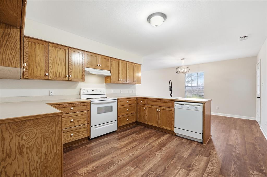710 Erath Street Meridian, TX 76665 - Photo 11 of 26 a kitchen with granite countertop a sink cabinets stainless steel appliances and a counter space