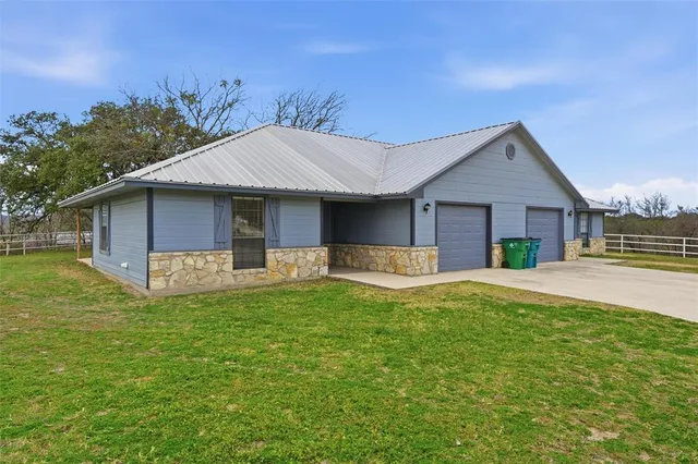 a front view of house with yard barbeque and outdoor seating