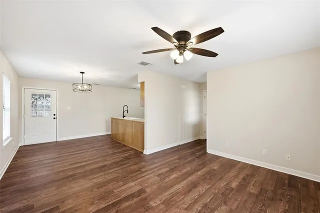 a view of a livingroom with wooden floor and a ceiling fan