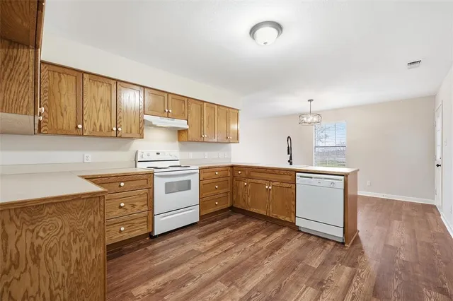 a kitchen with granite countertop a sink cabinets stainless steel appliances and a counter space